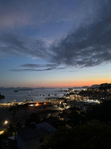 a view of a city at night with the ocean at Casa Bela Vista in Angra dos Reis