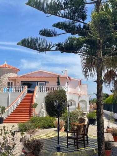 a house with stairs and a palm tree at California Dream Inn in Aljezur