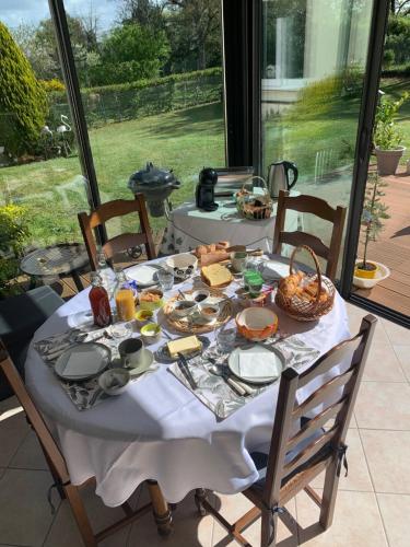 une table avec un chiffon de table blanc et de la nourriture dans l'établissement Chambres du Clos de Bellevue, à Vienne-en-Val