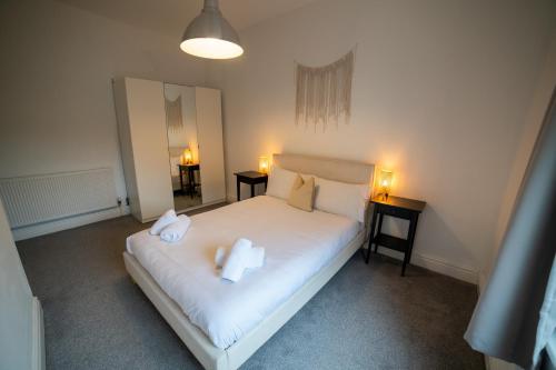 ein Schlafzimmer mit einem Bett mit zwei Handtüchern darauf in der Unterkunft Insurance Stays - Anfield L4 - Spacious house in Liverpool