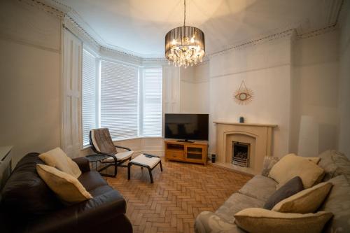 ein Wohnzimmer mit einem Sofa und einem TV in der Unterkunft Insurance Stays - Anfield L4 - Spacious house in Liverpool