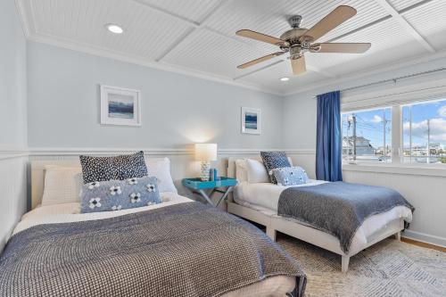 a bedroom with two beds and a ceiling fan at Bottoms Up! in Atlantic Beach