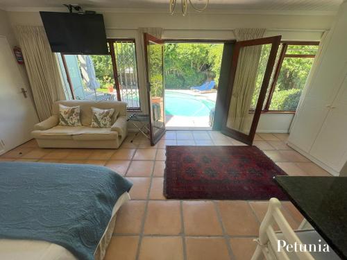 a bedroom with a bed and a view of a pool at Pinoak Self Catering Cottages - Constantia in Cape Town