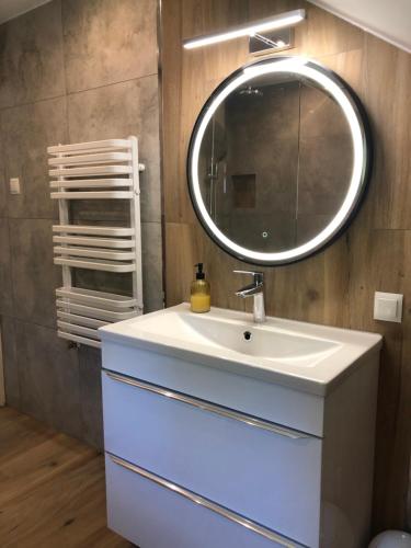 a bathroom with a white sink and a mirror at Apartamenty Krystyna in Wisła