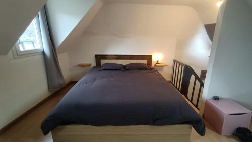 a bedroom with a large bed in a attic at Maison + parking. Calme, confort in Rouen