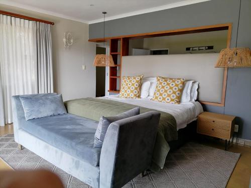 a bedroom with a large bed and a couch at Shingalana Cottages in White River