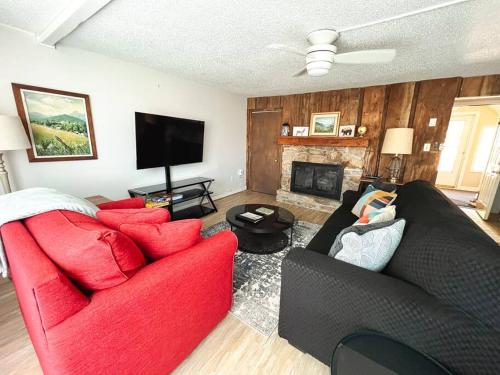 a living room with a red couch and a fireplace at Cozy & Peaceful View - Walk2Resort - Fireplace in Sugar Mountain
