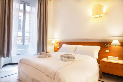 un letto bianco in una stanza con finestra di Hotel Domus Rome a Roma