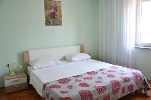 - une chambre dotée d'un lit avec une couverture rouge et blanche dans l'établissement Apartman Miki, à Fažana
