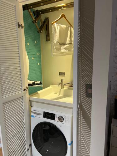 a washing machine in a bathroom with a sink at Luxurious 1 Br Facing Manila Bay Sunset Nearby Okada MOA Solaire Ayala Malls in Manila