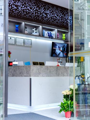 a glass wall with a shelf with a tv on it at Orient Rose International Hotel in Shanghai