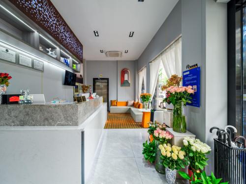 a lobby of a flower shop with vases of flowers at Rose International Hotel in Shanghai