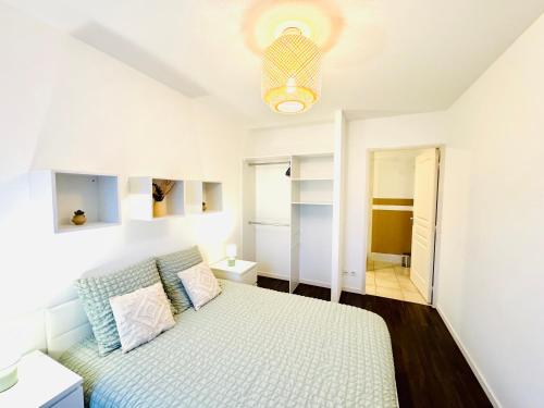 ein weißes Schlafzimmer mit einem Bett und einer Decke in der Unterkunft *Le Golden Tropic* Magnifique T4 Terrasse+Parking in Vaulx-en-Velin