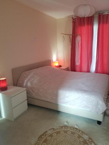 - une chambre avec un grand lit et des rideaux rouges dans l'établissement Grande villa 2 min plage - plein centre, à Vias