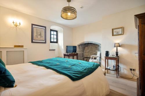 a bedroom with a bed with a blue blanket on it at Château de Saint Vidal in Le Puy en Velay