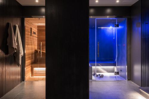 a bathroom with a shower with a blue glass door at Hotel Plaza Opéra in Palermo