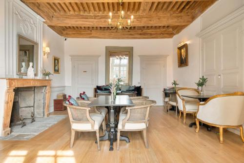 a dining room with tables and chairs and a fireplace at Château de Saint Vidal in Le Puy en Velay
