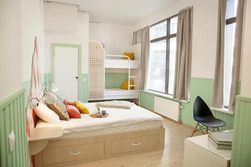 Habitación verde y blanca con cama y silla en NETIZEN Moscow Rimskaya, en Moscú