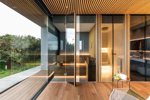 a house with glass doors and a wooden floor at Zash Country Boutique hotel & SPA in Giarre