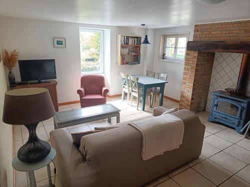 uma sala de estar com um sofá e uma lareira em Les Pieds dans l'eau, Gîte Le Blagour em Lachapelle-Auzac