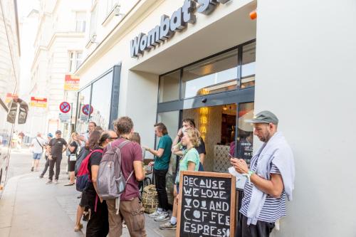 un groupe de personnes debout à l'extérieur d'un magasin dans l'établissement Wombat's City Hostel Vienna Naschmarkt, à Vienne