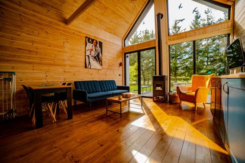un soggiorno con un divano e un tavolo di POCZUJ NATURĘ - domki nad jeziorem a Stare Wierzchowo