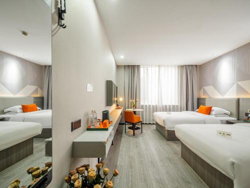 Habitación de hotel con 2 camas y escritorio en Rose International Hotel en Shanghái