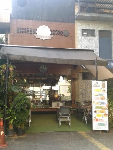 a restaurant with tables and chairs and an awning at Apartamento Parque Jardim Europa in Rio de Janeiro