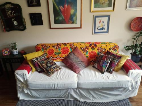 a white couch with colorful pillows on it at Apartamento Parque Jardim Europa in Rio de Janeiro