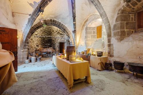 a room with two tables in a building with an archway at Château de Saint Vidal in Le Puy en Velay