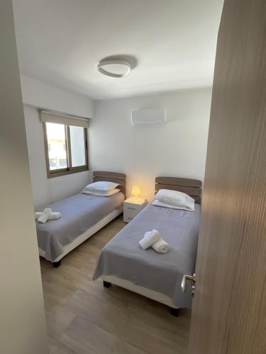 a room with two beds and a window at Le Voyageur II in Larnaca