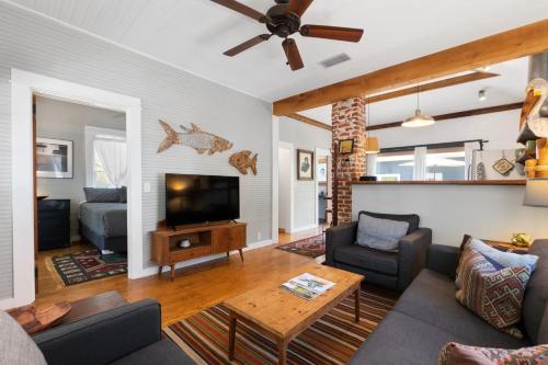 a living room with a couch and a tv at Cape Keepers Cottage - Lighthouse Park in St. Augustine