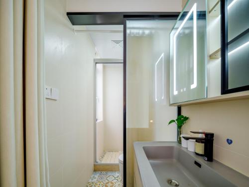 a white bathroom with a sink and a shower at Orient Rose International Hotel in Shanghai