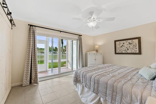 Un dormitorio con una cama y una puerta corrediza de vidrio. en Island Oasis - 3br 2ba - steps to the ocean!, en St. Augustine