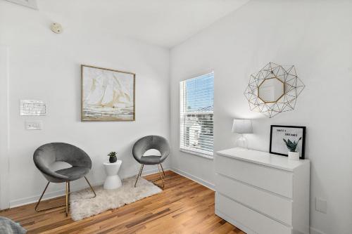 a white room with two chairs and a dresser at The Old Mission Collection - Downtown Bungalow in St. Augustine