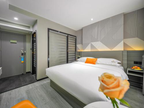 a bedroom with a large white bed and an orange flower at Orient Rose International Hotel in Shanghai