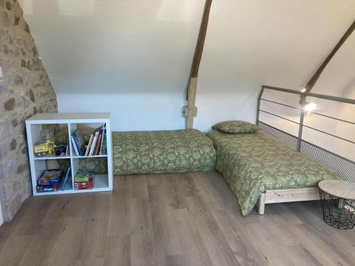 1 dormitorio con 2 camas y estante para libros en Erquy Les Hirondelles, en Erquy