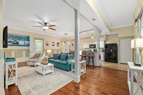 a living room with a blue couch and a kitchen at The Ray- 1st Floor Charming Condo- Walk to Downtown in St. Augustine