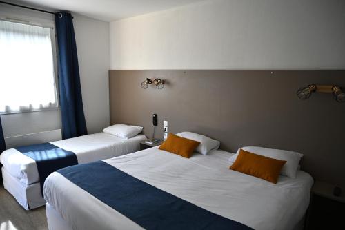 a hotel room with two beds and a window at Cit'Hotel Les Eleis in Saint-Martin-de-Fraigneau