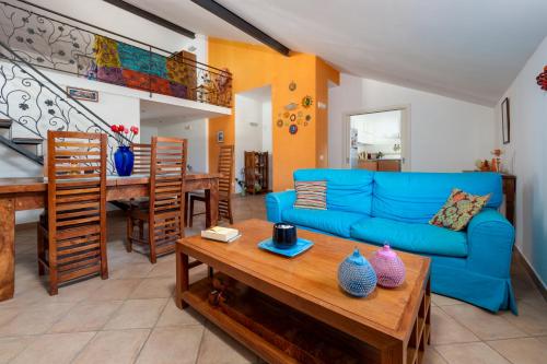 een woonkamer met een blauwe bank en een tafel bij La Mela in Meta