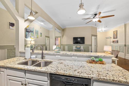 Una cocina con fregadero y una sala de estar. en The Ray- 1st Floor Charming Condo- Walk to Downtown, en St. Augustine