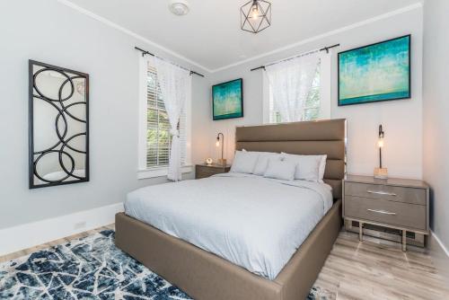 a bedroom with a large bed and two windows at 20 Hypolita - Luxury Downtown Apartment in St. Augustine
