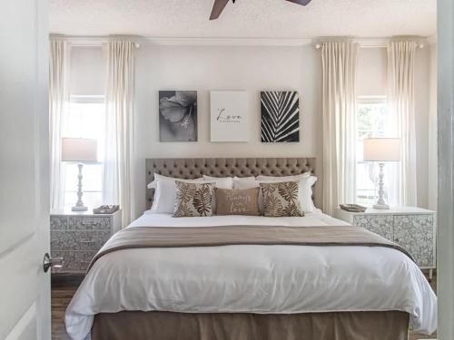 聖奧古斯丁的住宿－Private Romantic Retreat Mins DWTN Beach，一间卧室设有一张大床和两个窗户