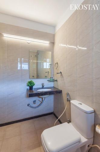 a bathroom with a toilet and a sink and a mirror at Ekostay Kingfisher Villa I Indoor Pool I Cloud 9 in Lonavala