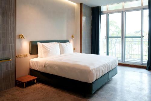 a bedroom with a large bed and a large window at PAPO'A Harbor Hotel in Kaohsiung
