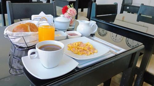 a breakfast table with a cup of coffee and a plate of food at Di Costa Hoteles in Piura