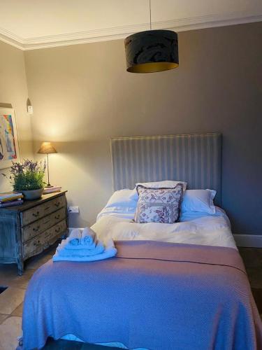 una camera da letto con un letto con una coperta blu sopra di Beautiful 4-Bed House in Kildare a Kildare
