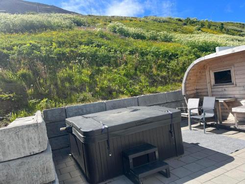 a trash can sitting on a patio next to a building at Charming villa with hot tub and sauna in Suðureyri