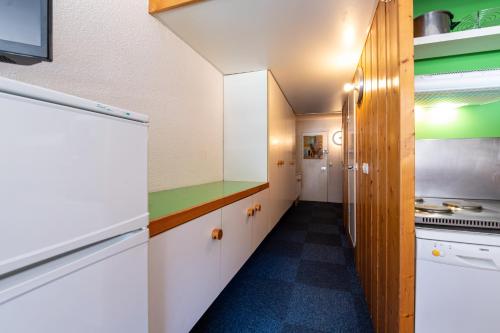 d'une cuisine avec des placards blancs et des touches de vert. dans l'établissement Studio Pierra Menta Vue Mont Blanc, à Arc 1800