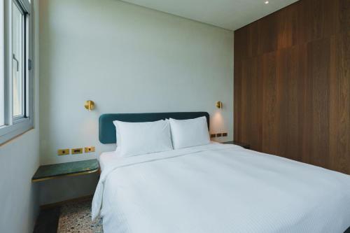 a large white bed in a room with a window at PAPO'A Harbor Hotel in Kaohsiung